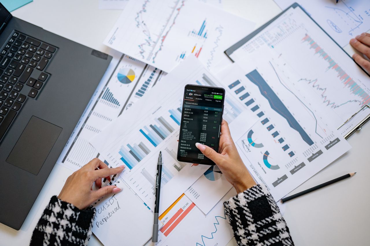Services-02 Vue de dessus sur des graphiques et un smartphone dans un bureau, mettant en avant l'analyse de données.